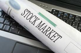 rolled-up-stock-market-newspaper-on-top-laptop-keyboard